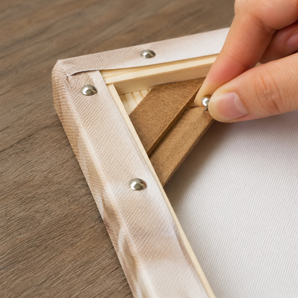 fixing the canvas to the frame back with metal push pins | DIY Wooden Canvas Stretcher Frame