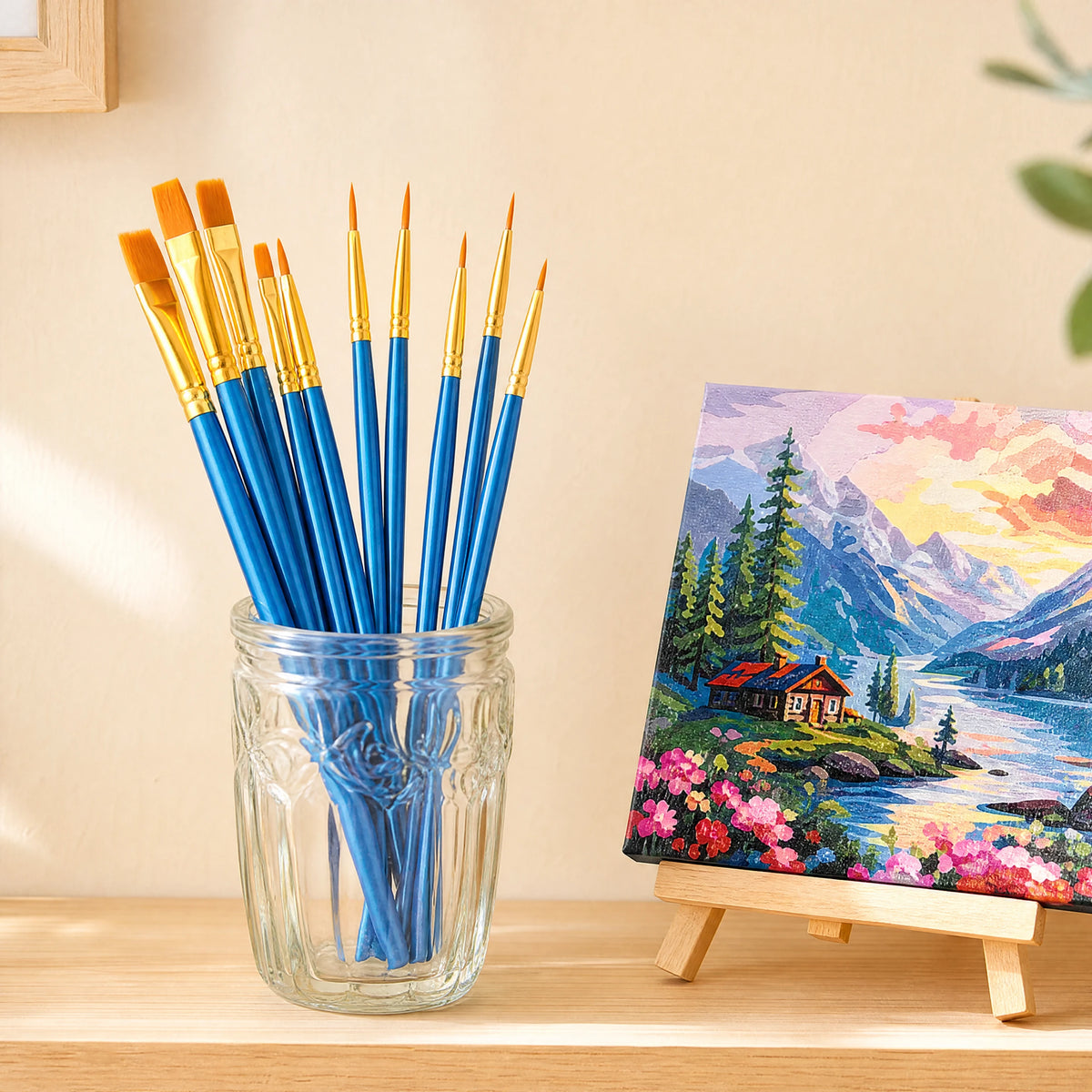 blue paint brushes in a glass jar next to a finished canvas | Detail Paint Brush Set of 8 + 2 FREE