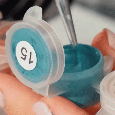 Close-up of acrylic paint being applied to a numbered canvas cell