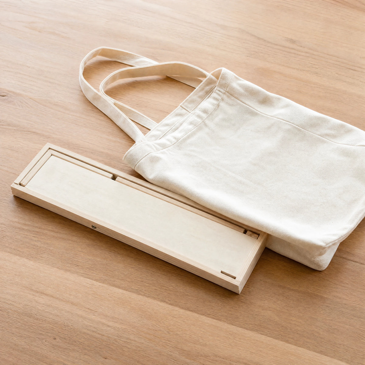 easel folded flat next to a tote bag, slim and portable | Foldable Wooden Tabletop Easel